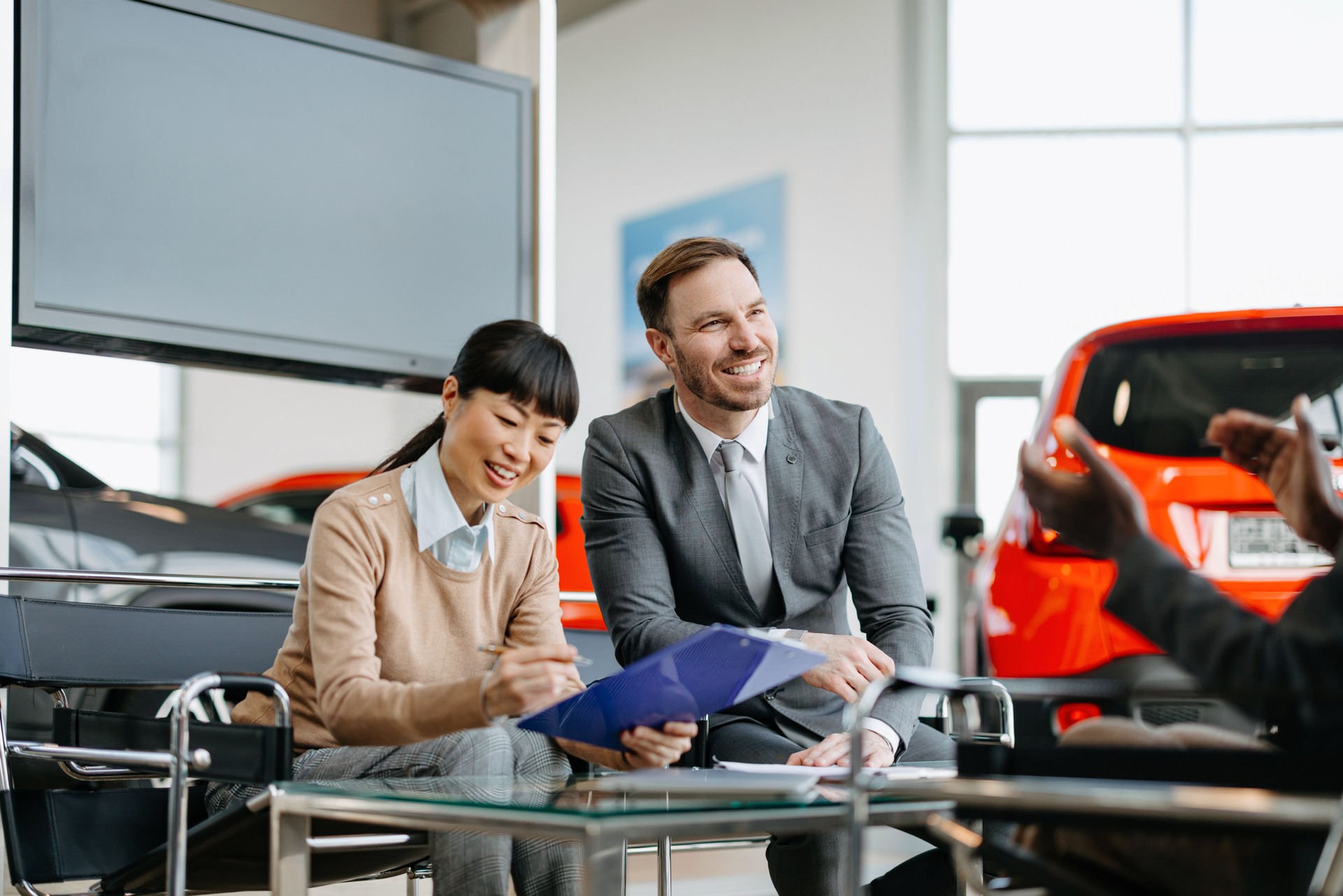 Couple listens to sales pitch in car showroom